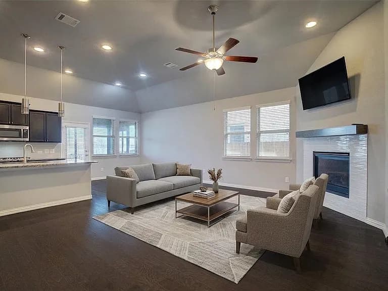 The same living room with a digitally added sofa, chairs, rug and coffee table